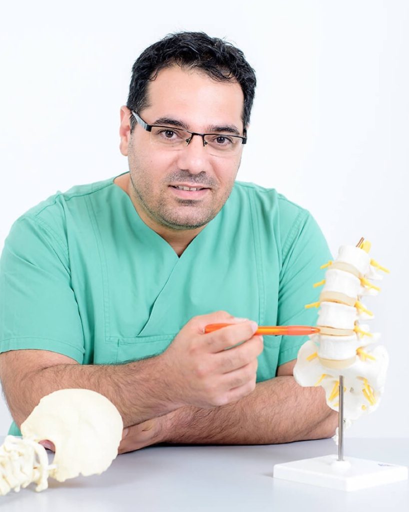 Eyad Al-Kahlout, Facharzt für Neurochirurgie, erläutert ein Modell der Wirbelsäule